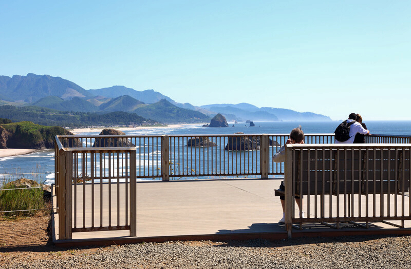 Viewpoint area overlooking Ecola State Park. Fenced, flat surface with seating.