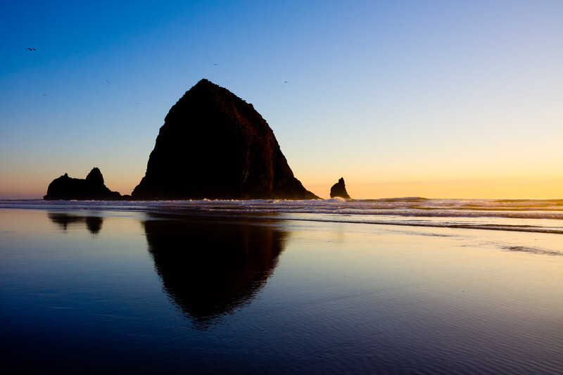 A beautiful clear sky sunset of Haystack Rock in Cannon Beach.