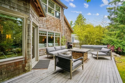 Back yard deck of cedar shingled 2-level beach house, luxury outdoor furniture, fire table, BBQ, and hot tub