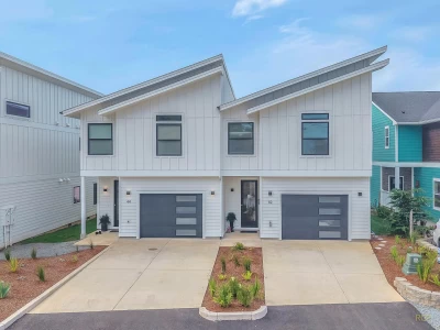 Two-level creamy white colored, modern townhouse with black trim.
