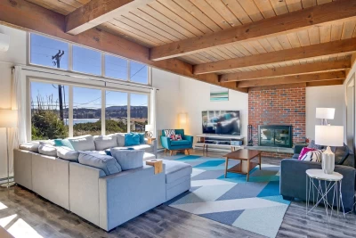 Oceanfront vacation home in Waldport Oregon with sandy beach backyard, large windows, sunroom, and panoramic Pacific Ocean views