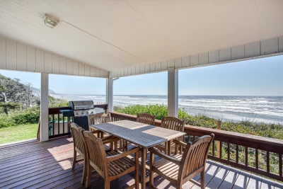 Oceanfront single-story beach house on a bluff with covered porch, hot tub, and stunning views of the sandy Oregon Coast.