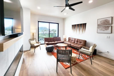 Bright open living room with large windows and sliding glass door overlooking Waldport and the Alsea Bay