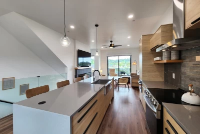 Bright open kitchen with island and dining table, large windows, and sliding glass door overlooking Waldport