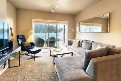 Modern living room with large smart TV and sliding glass door overlooking the Siuslaw River