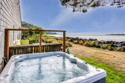 View of Alsea Bay, hot tub, yard furniture in grassy yard